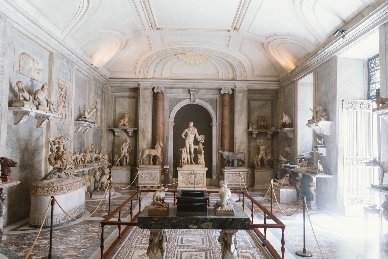 Prunkvoller Skulpturensaal mit antiken Statuen und Mosaikboden