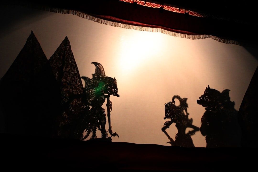 Schattenfiguren eines traditionellen Schattenspiels vor beleuchteter Leinwand